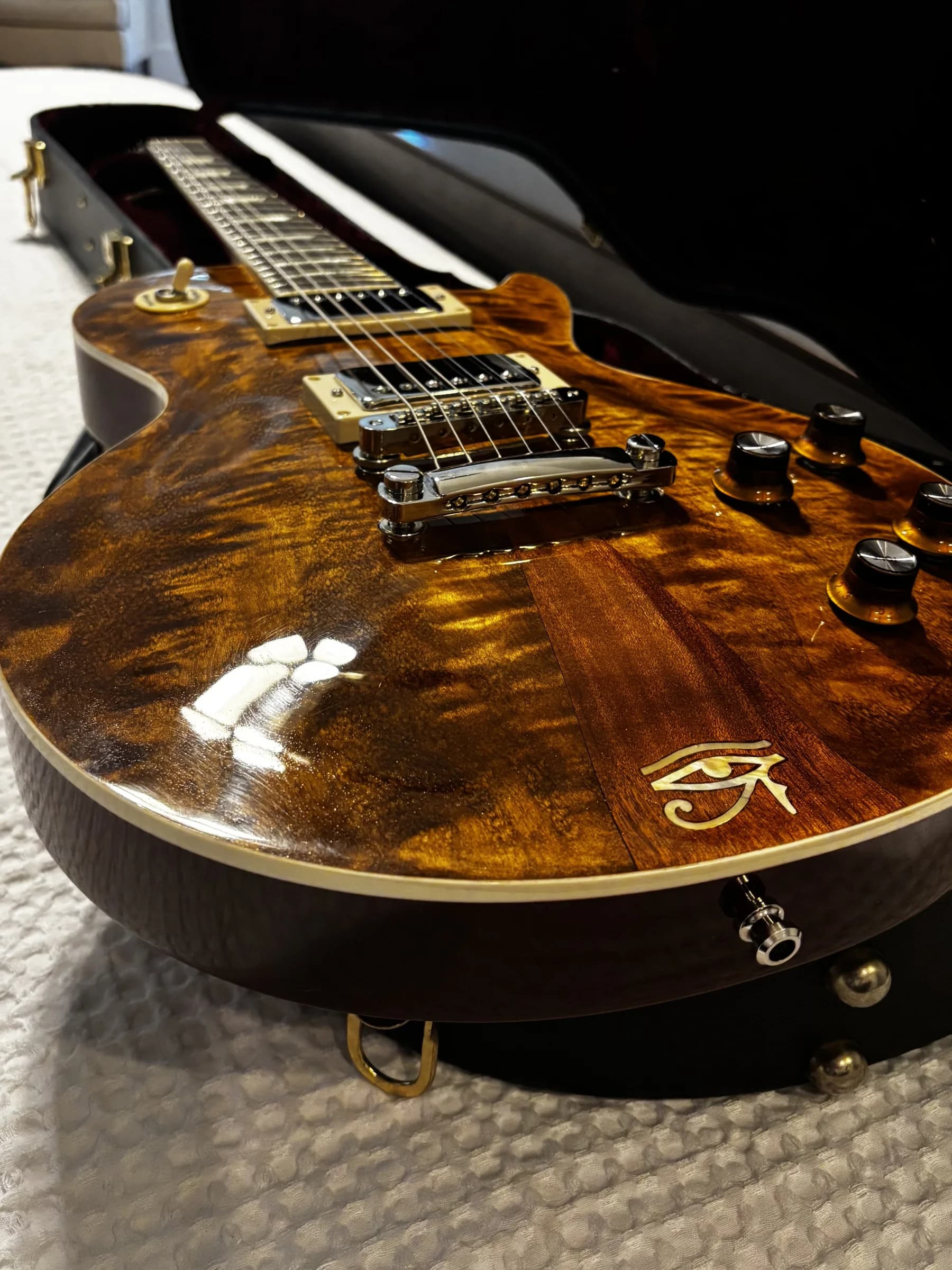 Close view of figured wood, binding, and hardware on an SJR guitar