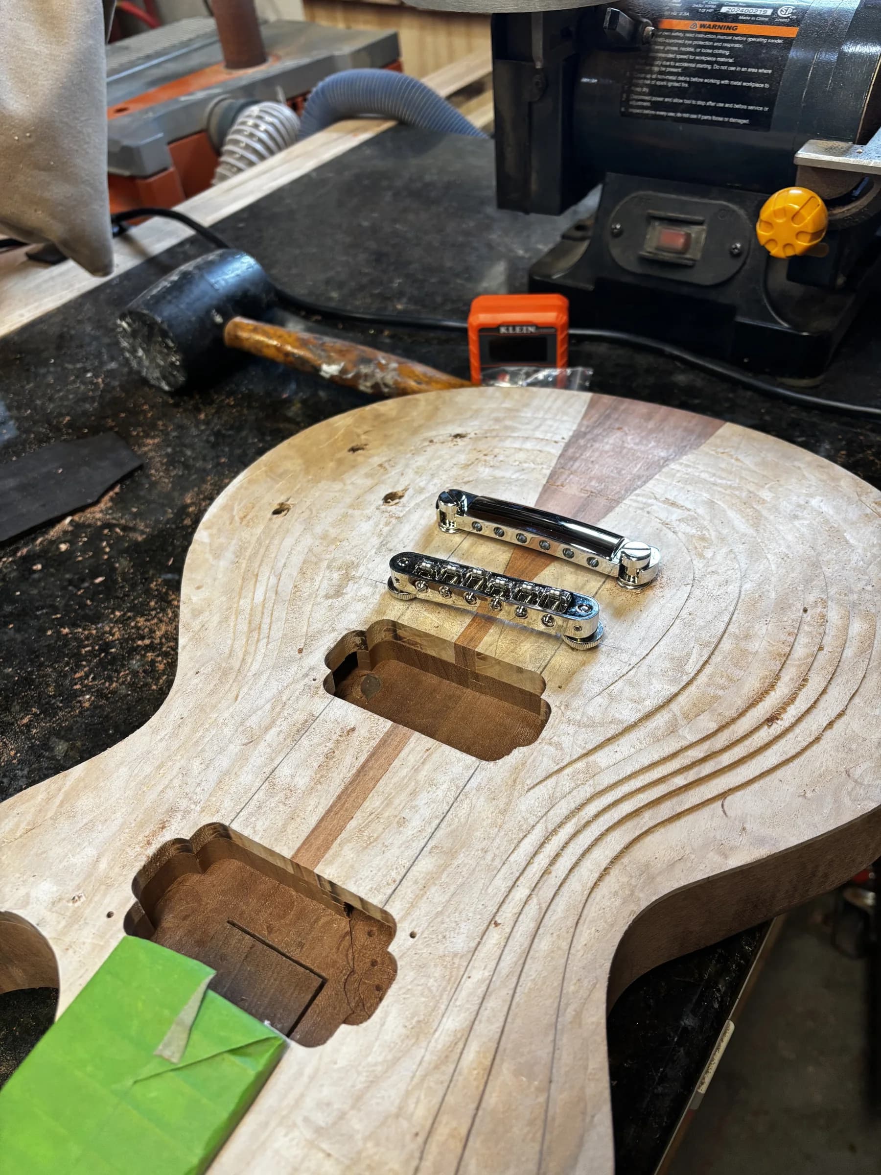 Routed figured guitar body with bridge hardware test-fitted