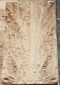 Vertical figured wood blank with a drawn guitar-body outline